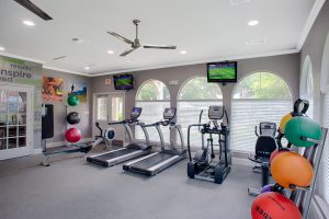 Fitness center with treadmills, rowing machine, tvs, stair step machine, cycle and weights with big windows