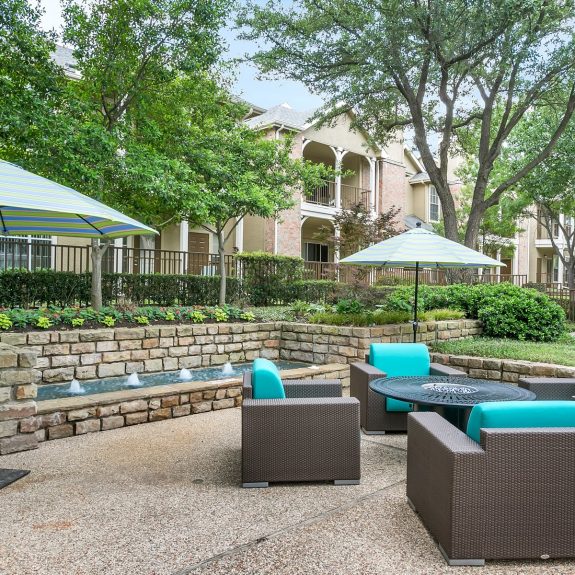 Outdoor Courtyard area with umbrellas, fire pit, fountains, and Modern Seating