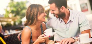 Couple Smiling outdoors with coffee at restaurant