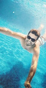 Man underwater diving smiles
